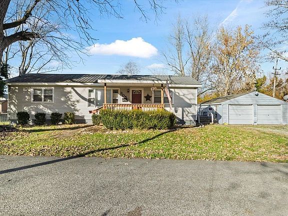 A house with a garage and a porch on a sunny day.