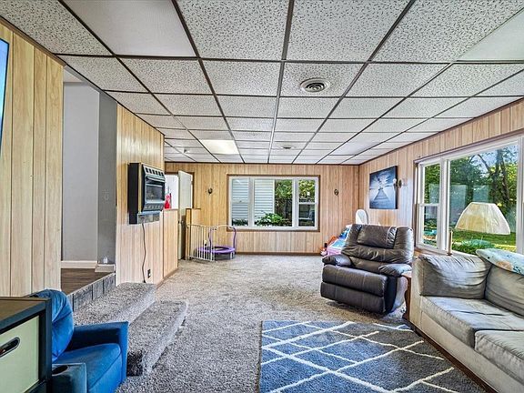 A living room with a couch , chair , and television.