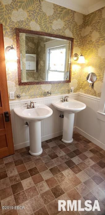 A bathroom with two sinks and a mirror.