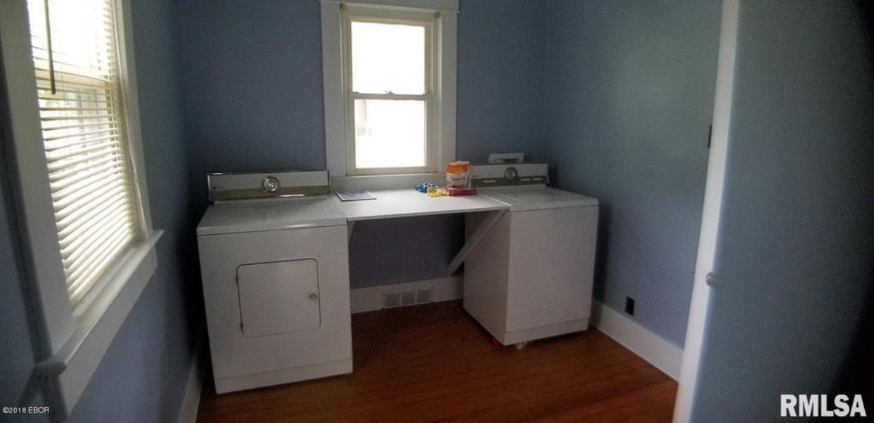 A laundry room with a washer and dryer and a window.