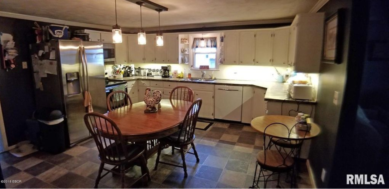 A kitchen with a table and chairs and a refrigerator.