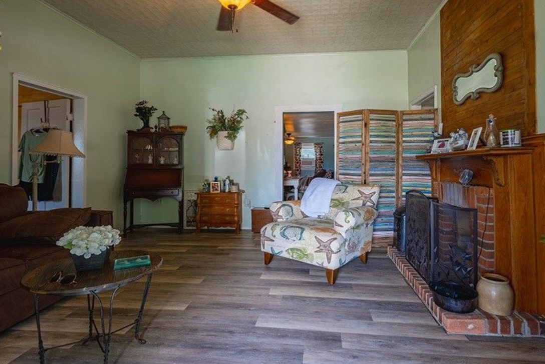 A living room with a couch , chair , table and fireplace.