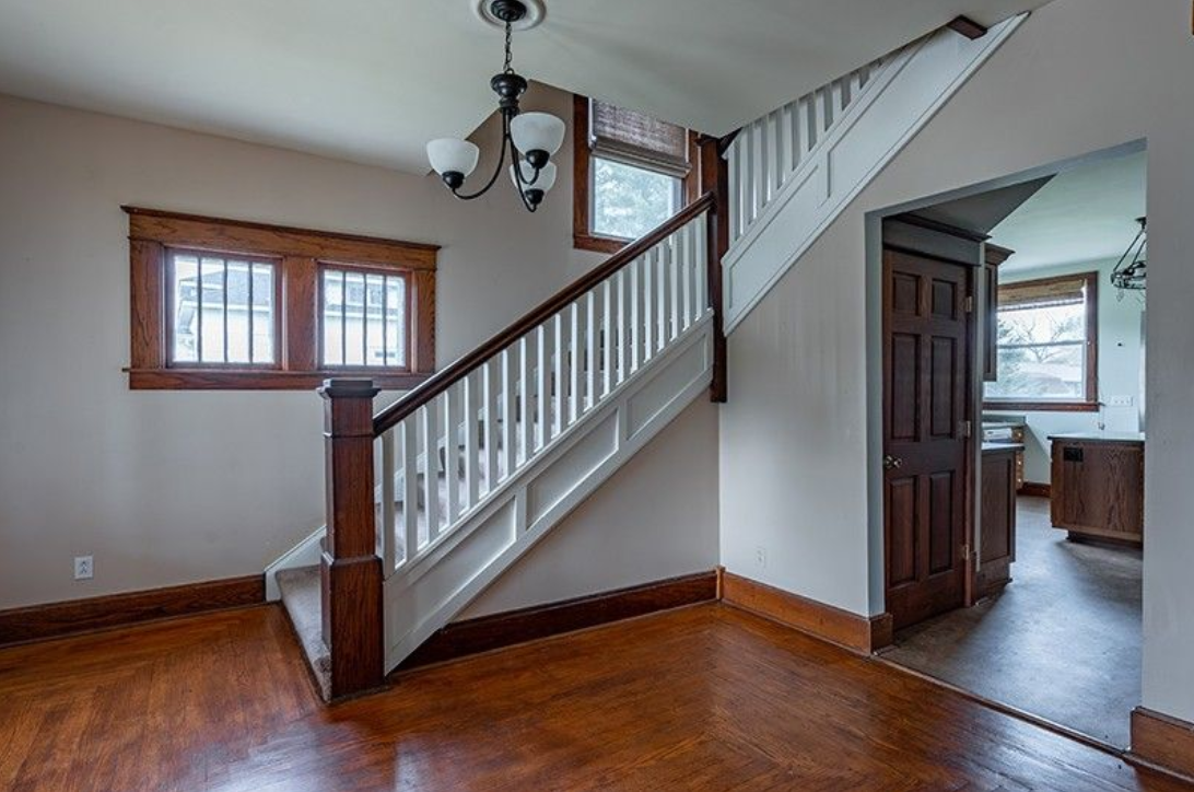 An empty room with a staircase leading up to the second floor.