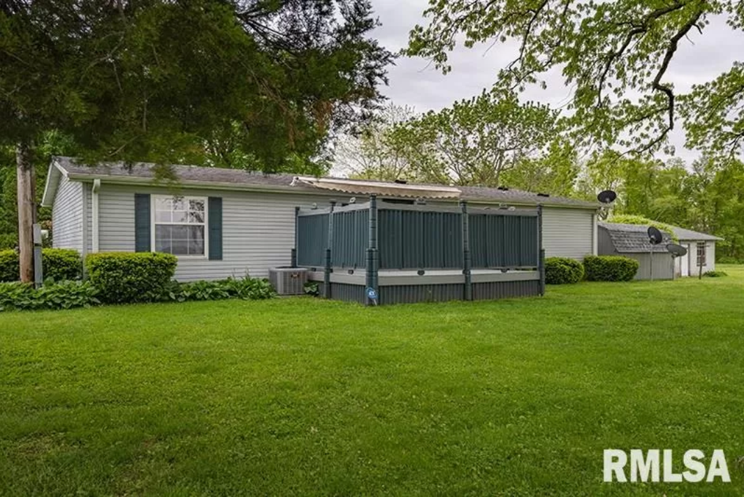 A mobile home is sitting in the middle of a lush green field.