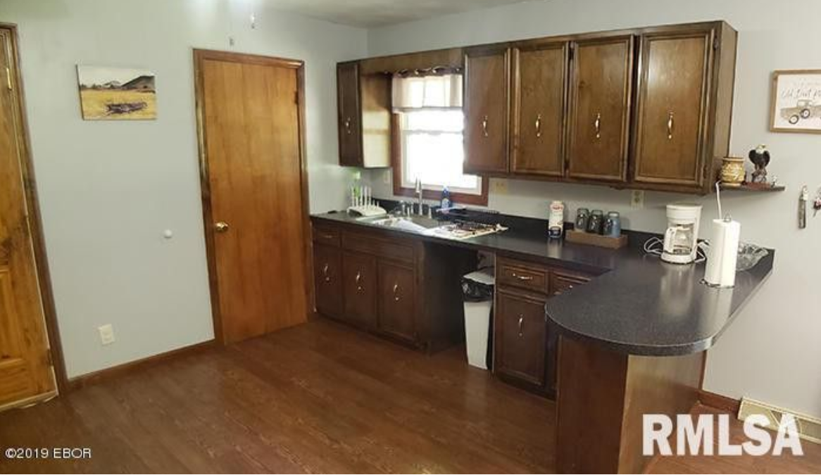 A kitchen with wooden cabinets and a black counter top.