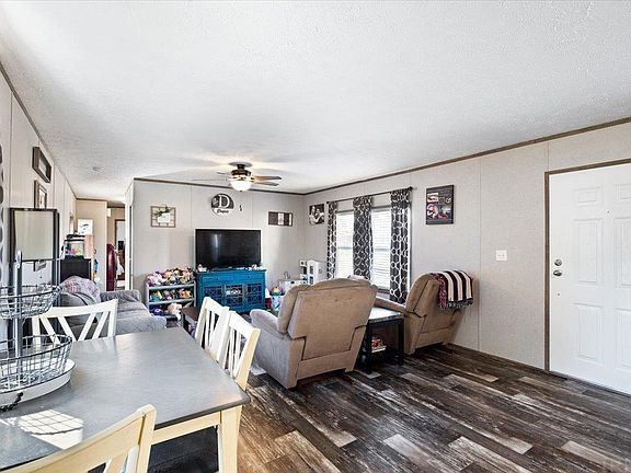 A living room with a table , chairs , and a television.