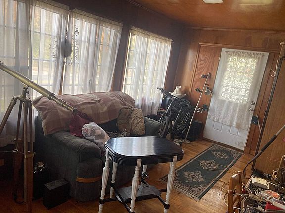 A living room with a couch , table , and telescope.