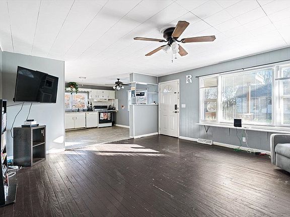 A living room with hardwood floors and a ceiling fan.