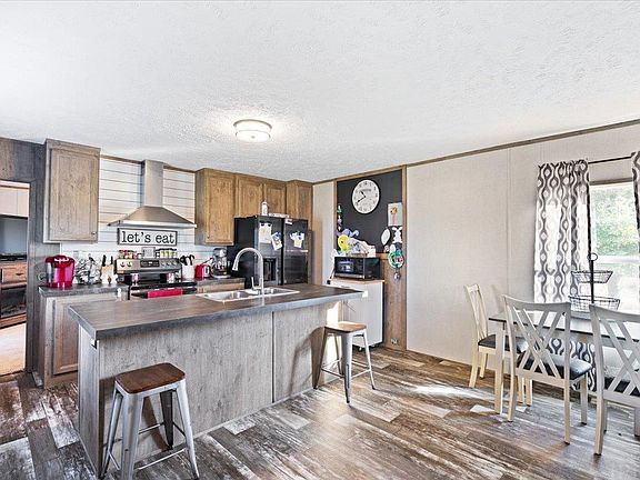 A kitchen and dining room in a mobile home with a large island.