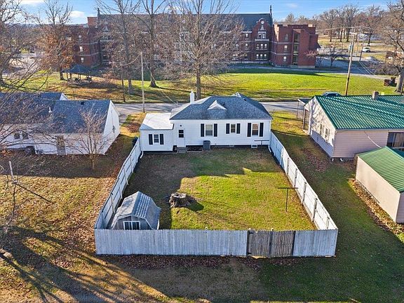 An aerial view of a house with a fence around it.