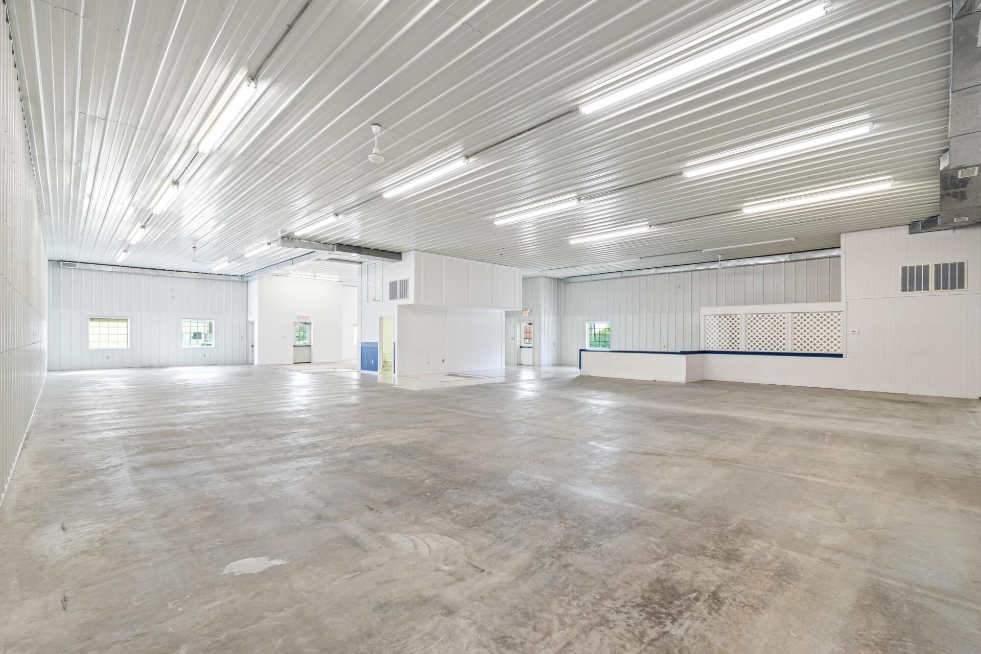 A large empty warehouse with a concrete floor and white walls.