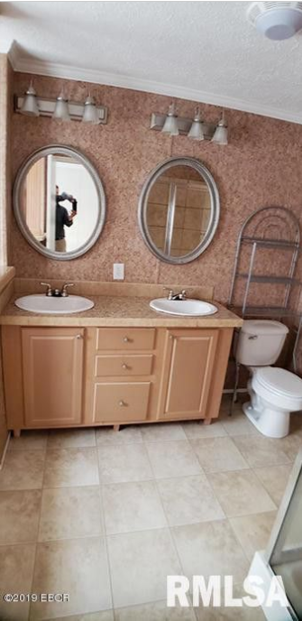 A bathroom with two sinks , a toilet and two mirrors.