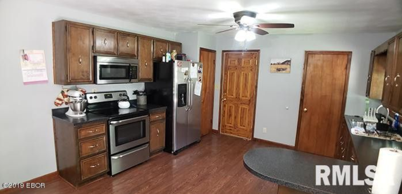 A kitchen with stainless steel appliances and wooden cabinets.