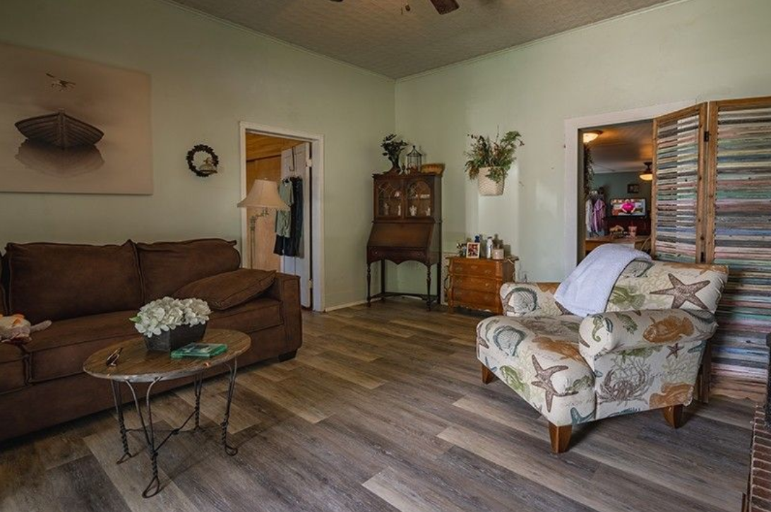 A living room with a couch , chair , and table.