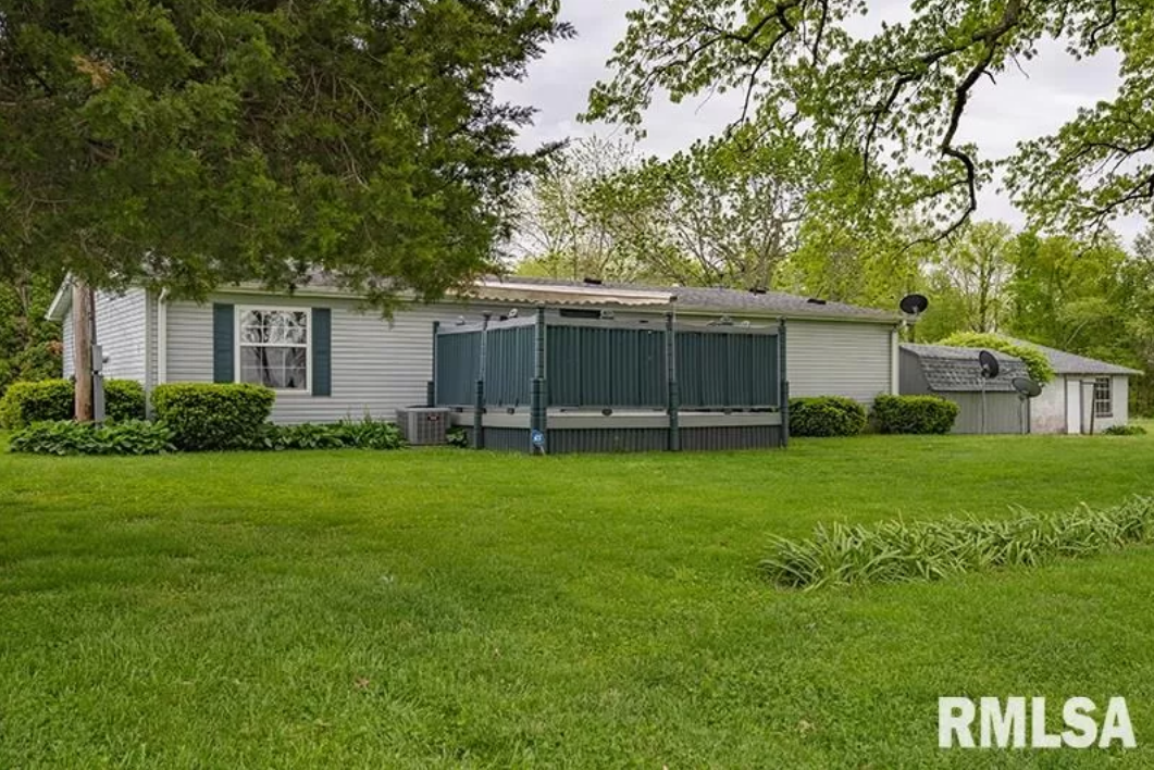 A mobile home is sitting in the middle of a lush green field.