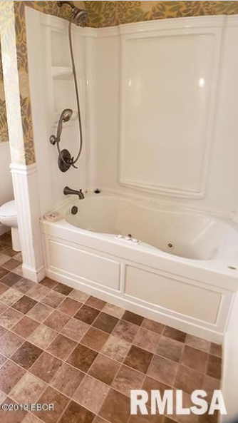 A bathroom with a bathtub and a shower.