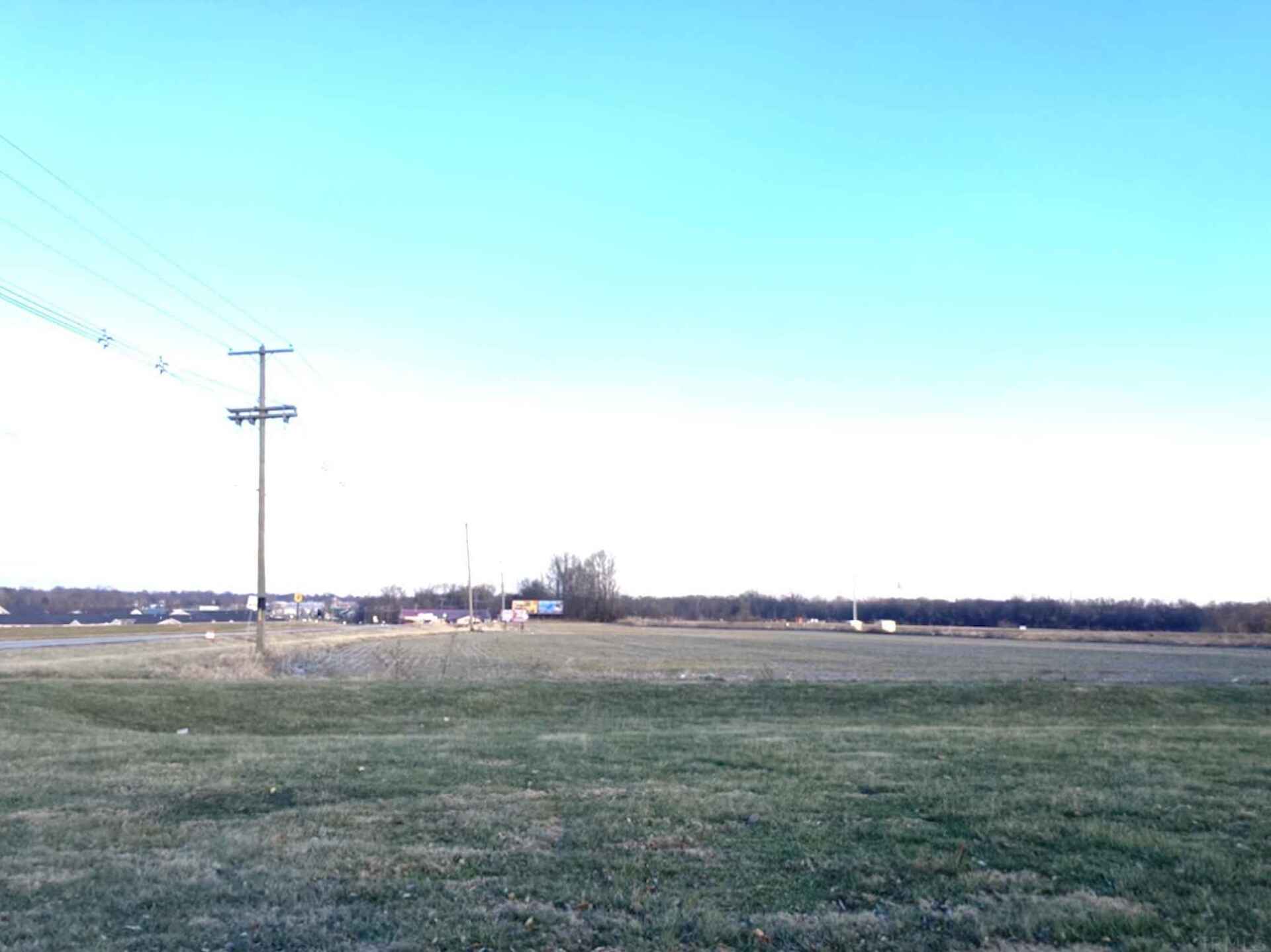 A large grassy field with a blue sky in the background.