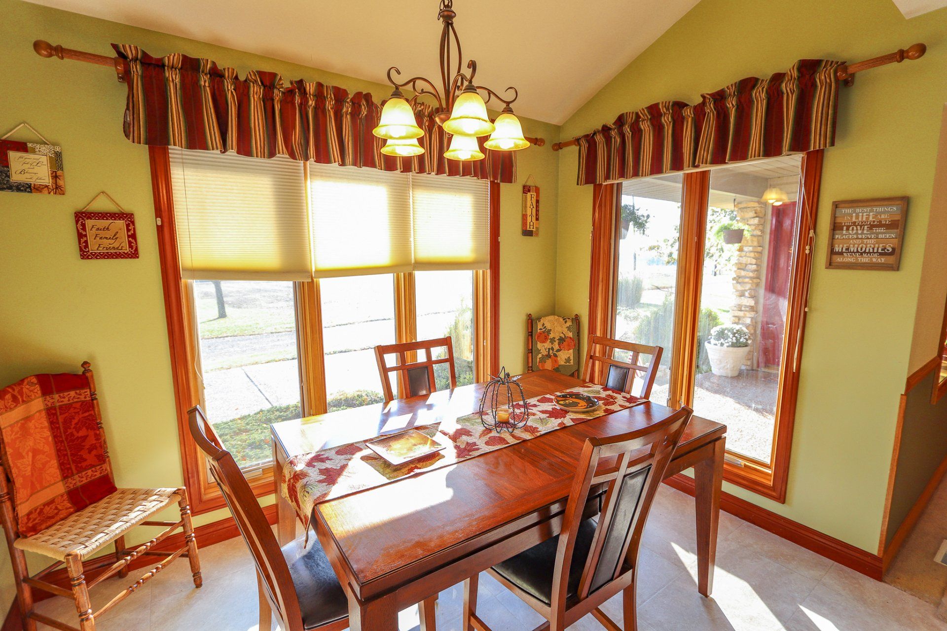 A dining room with a table and chairs and lots of windows