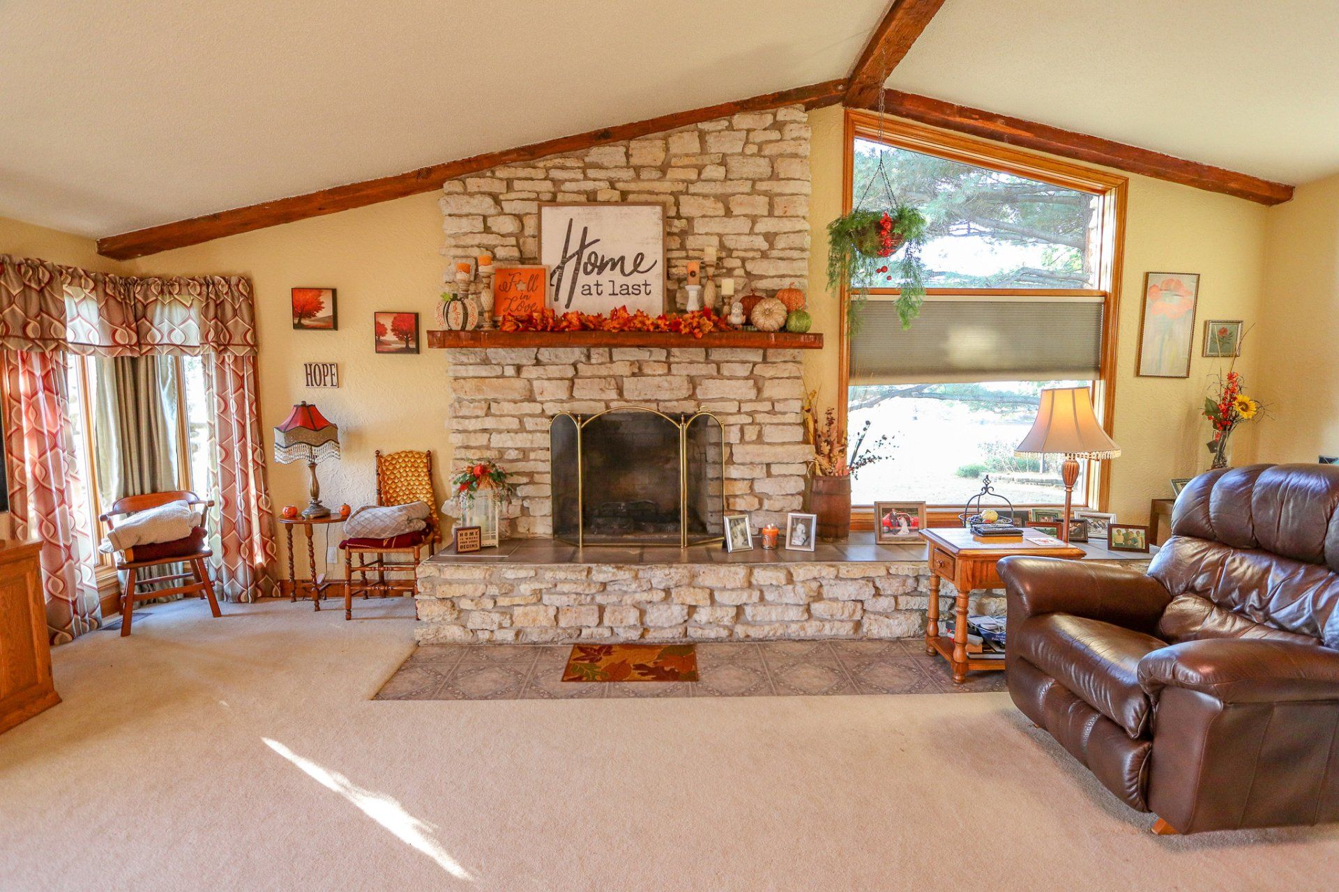 A living room with a stone fireplace and a couch.