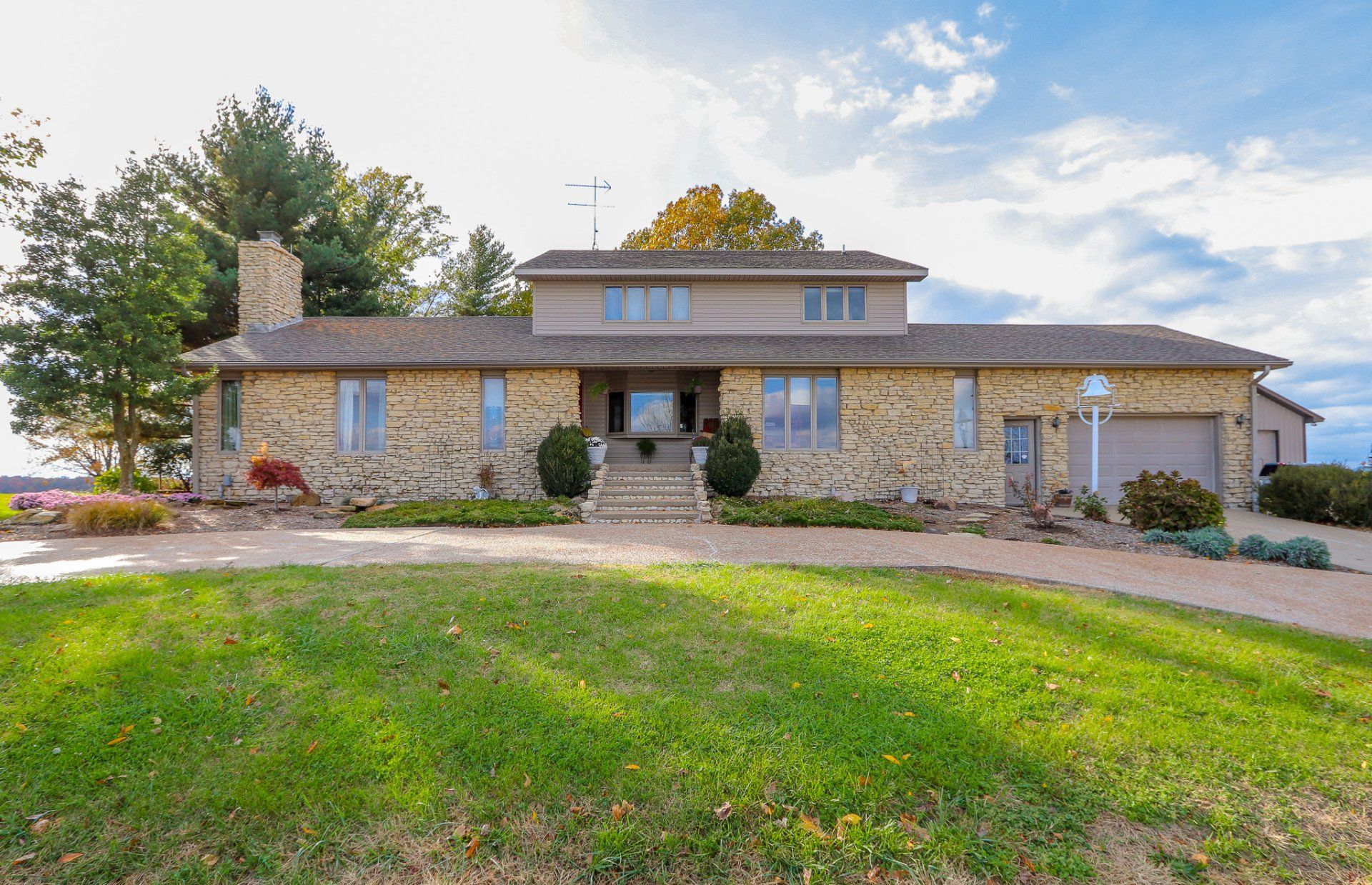 A large stone house with a large lawn in front of it.