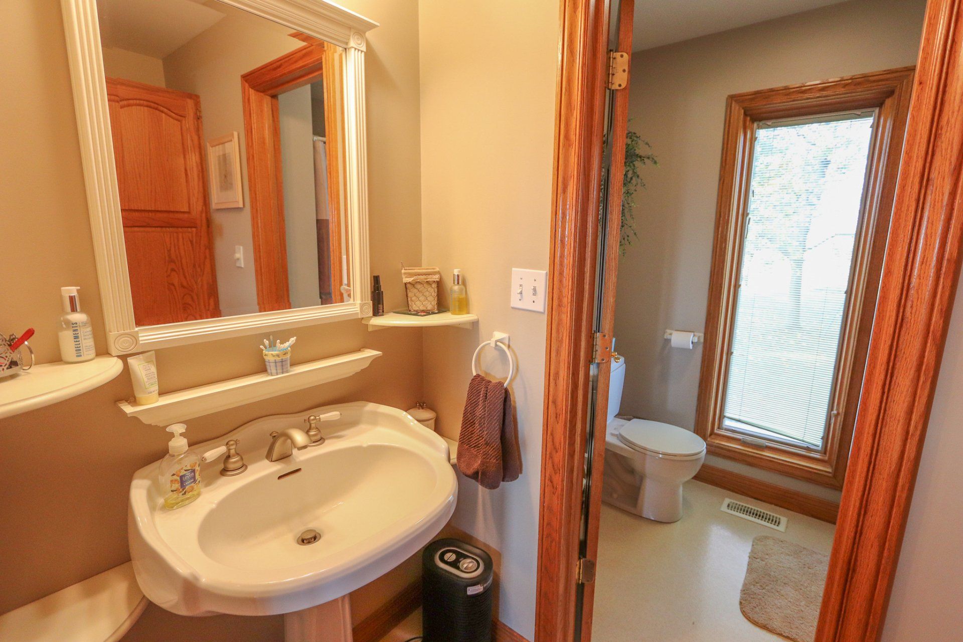 A bathroom with a sink , toilet and mirror.
