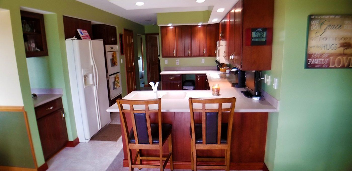 A kitchen with green walls and a picture on the wall that says love