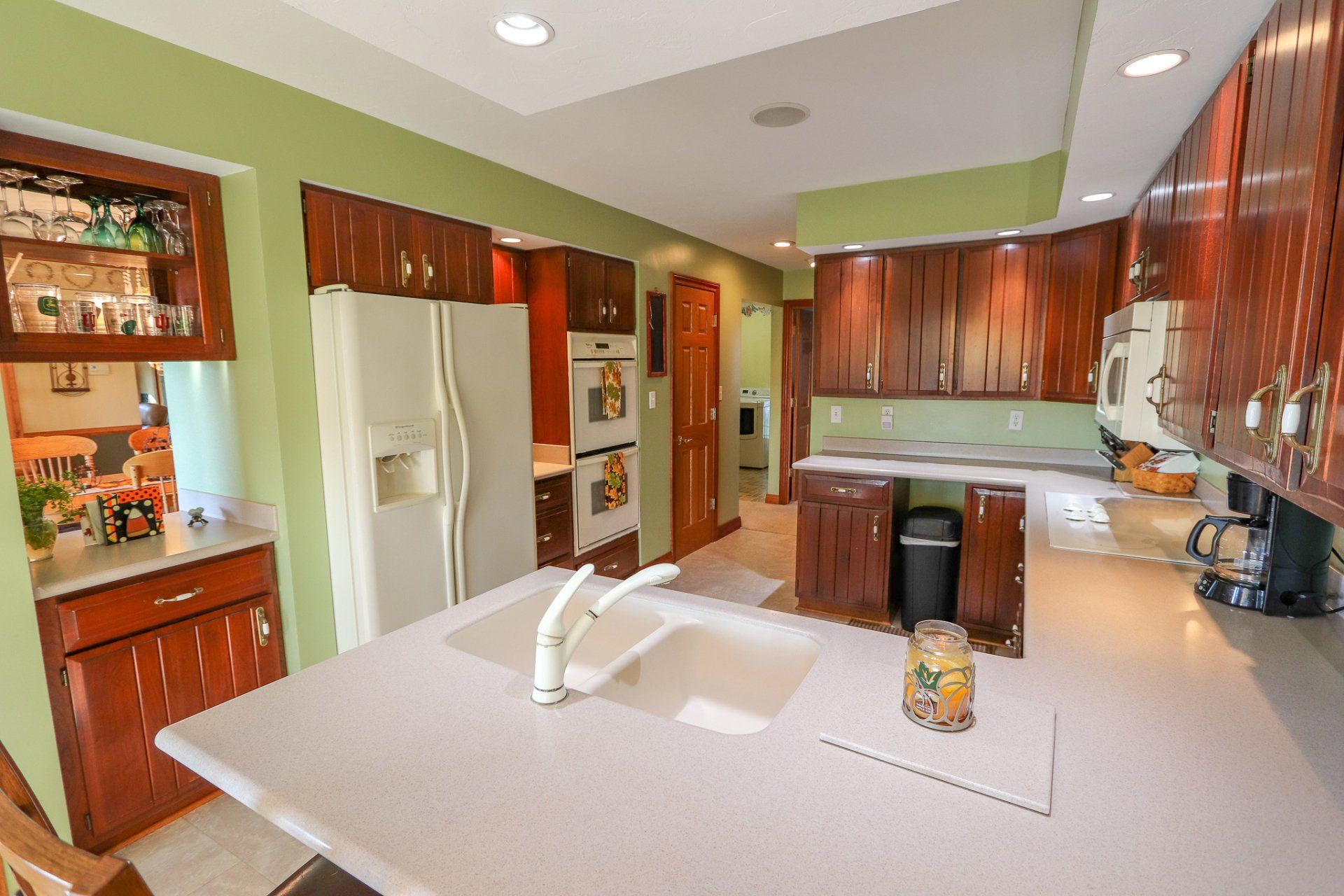 A kitchen with a sink , refrigerator , and stove.