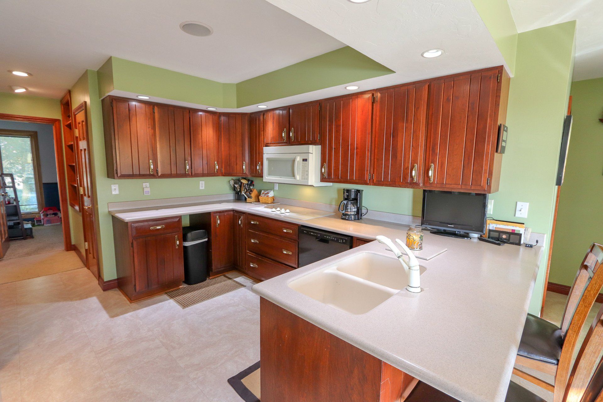 A kitchen with wooden cabinets and white counter tops