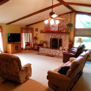 A living room with a fireplace and a sign that says home sweet home