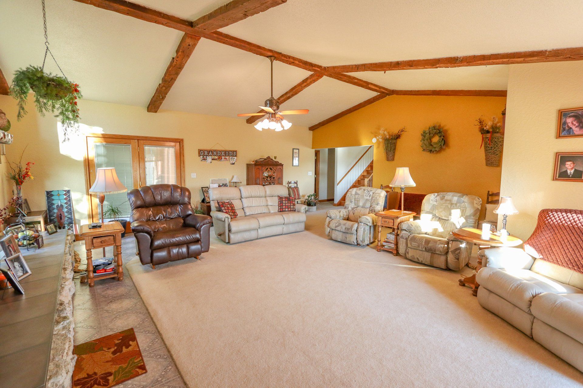 A living room with a lot of furniture and a ceiling fan