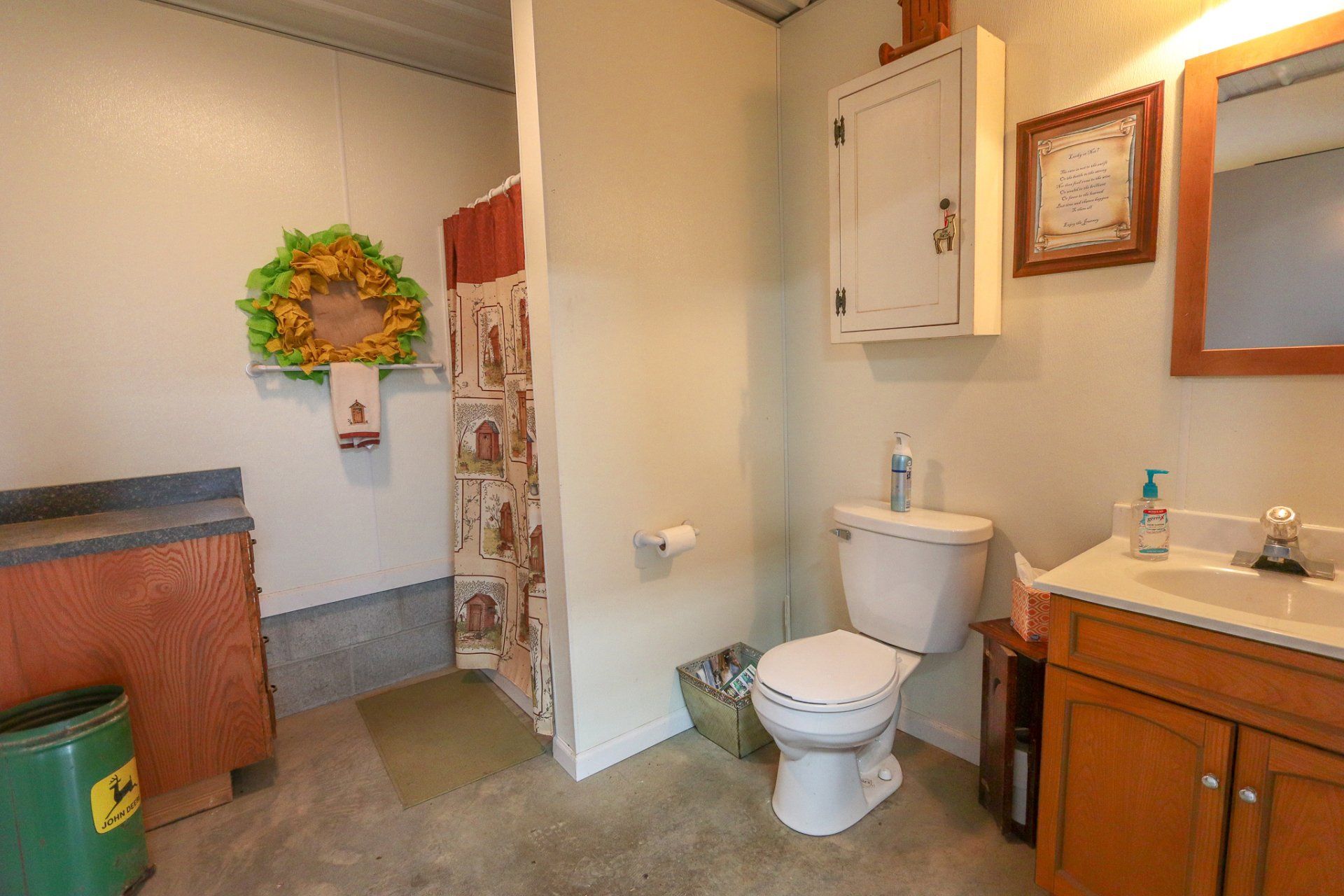 A bathroom with a toilet , sink and mirror.