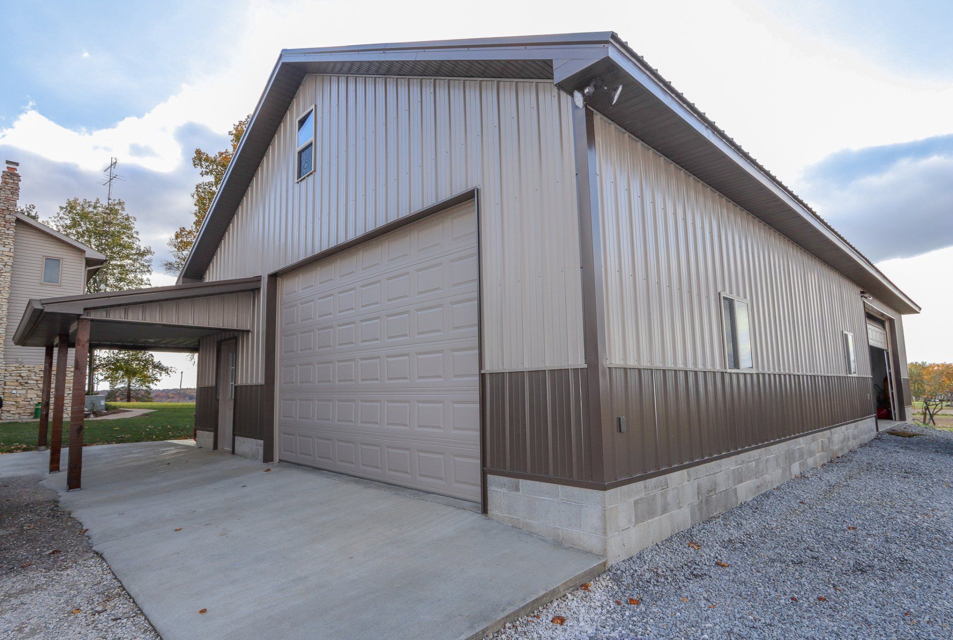 A large barn with a carport attached to it.