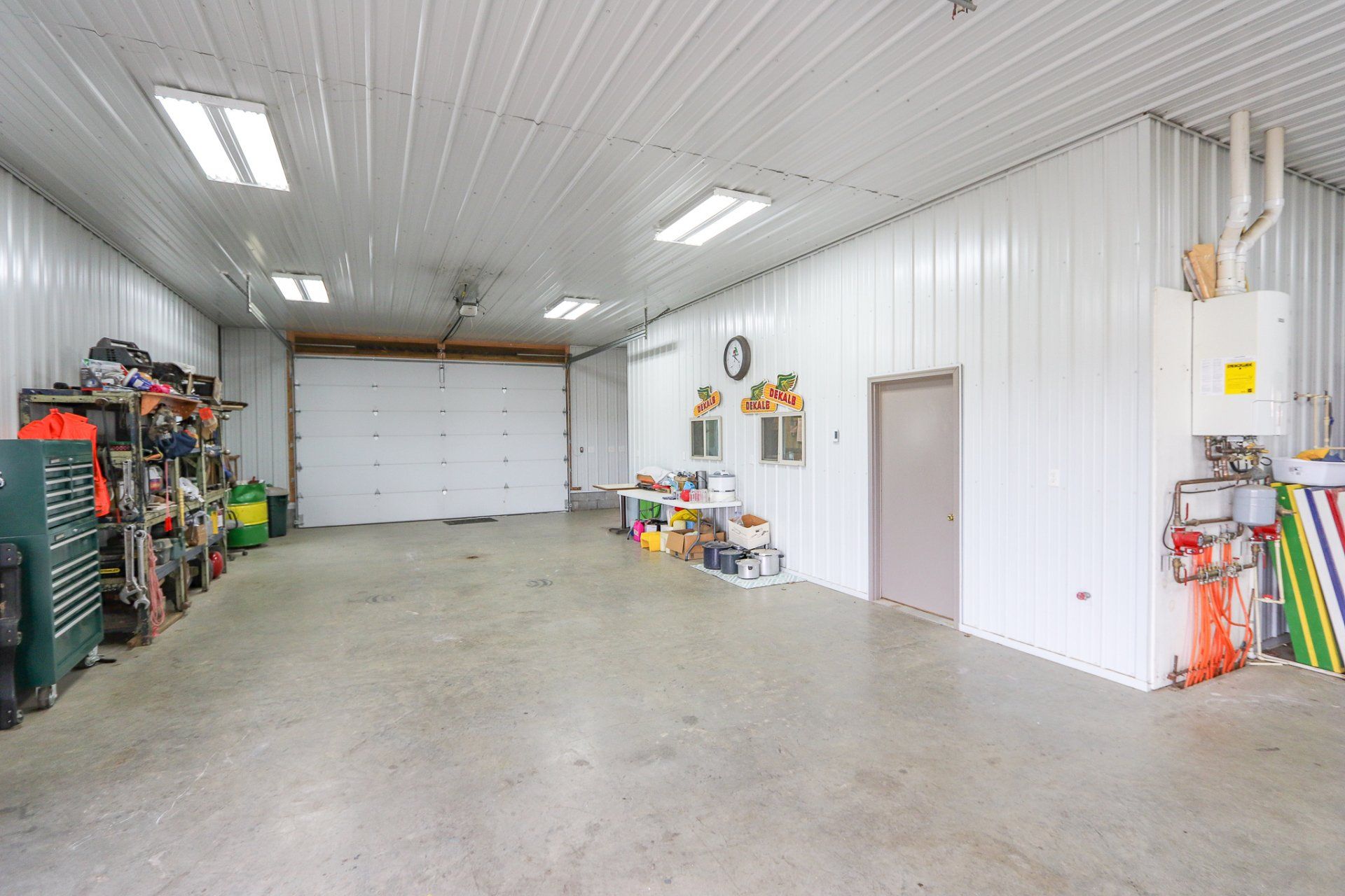 There is a garage with a garage door and a lot of tools in it.