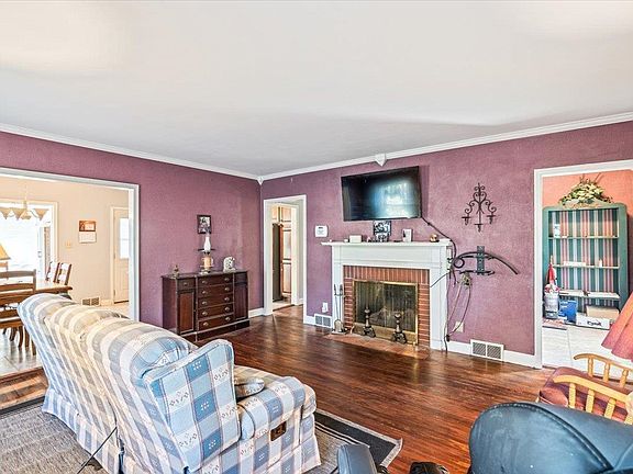 A living room with a fireplace , couch , chair and television.