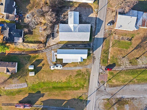 An aerial view of a residential area with a red car driving down the street.