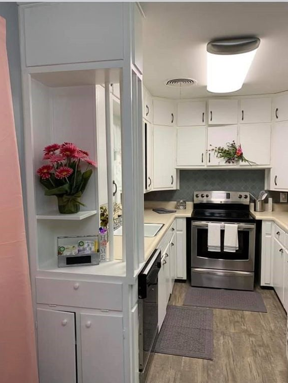 A kitchen with white cabinets and stainless steel appliances