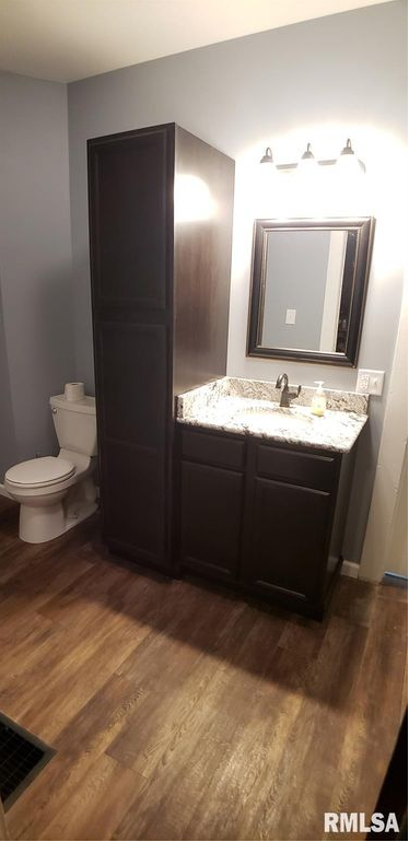 A bathroom with a toilet , sink and mirror.