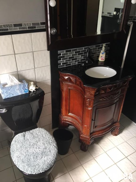 A bathroom with a toilet a sink and a mirror