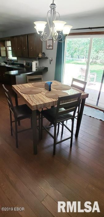 A dining room with a table and chairs and a sliding glass door.