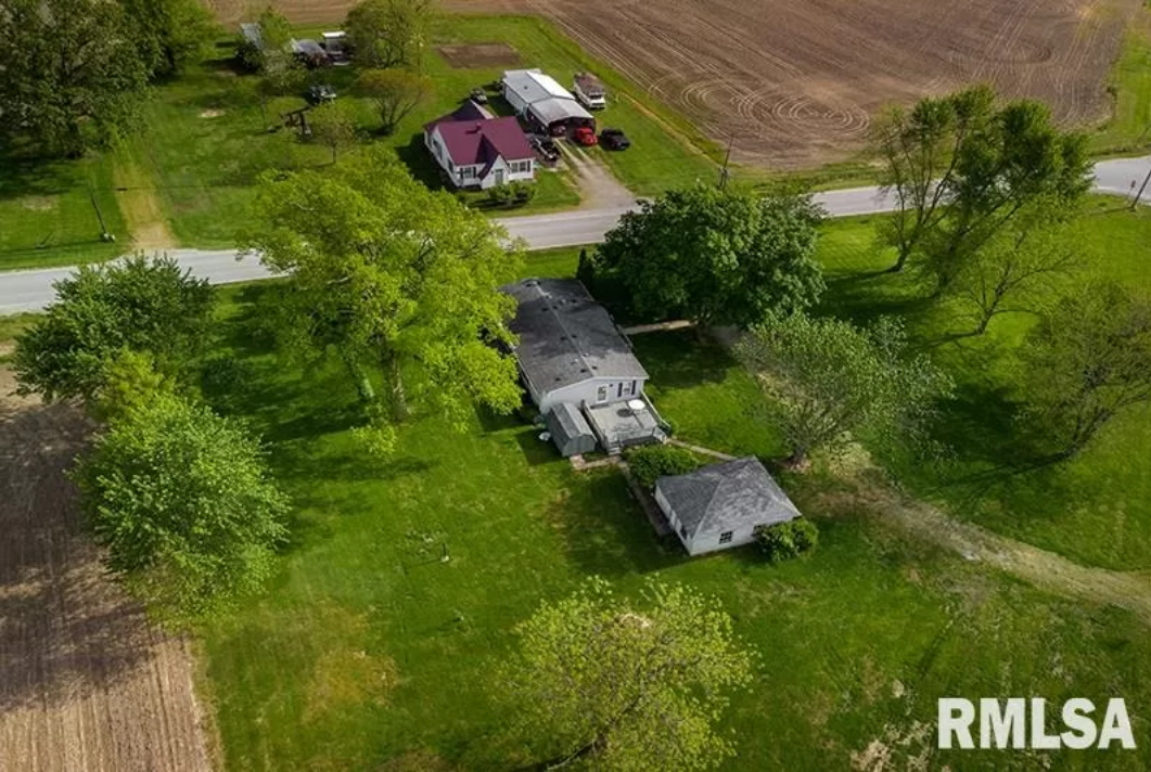 An aerial view of a farm with a lot of trees and houses.
