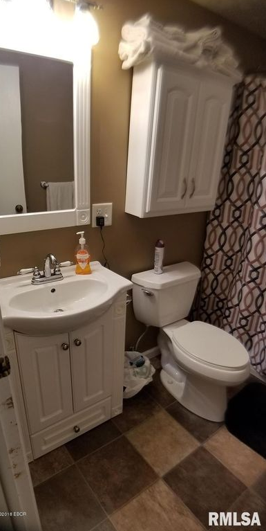 A bathroom with a sink , toilet and mirror.
