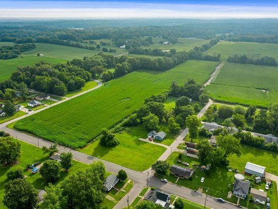 An aerial view of a residential area with lots of green fields and houses.