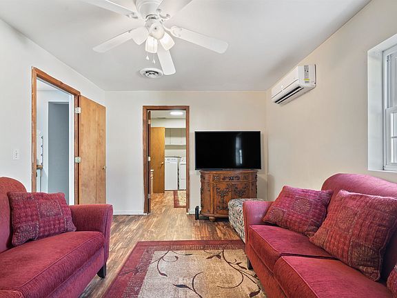 A living room with two red couches and a flat screen tv.