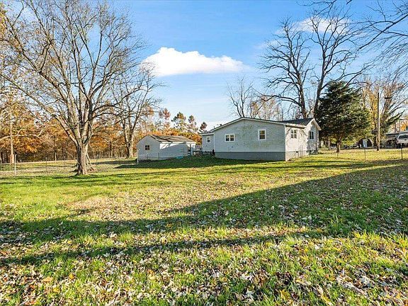 A couple of mobile homes are sitting on top of a lush green field.