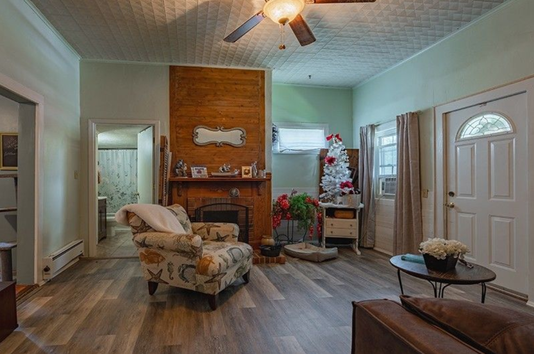 A living room with a couch , chair , table and fireplace.