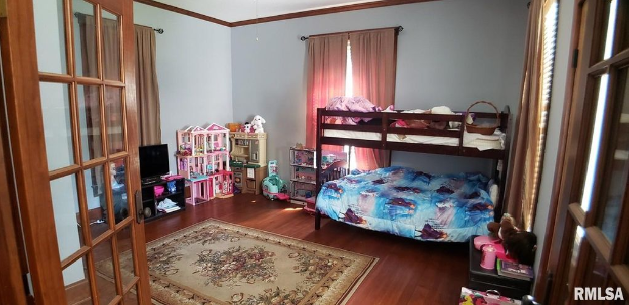 A bedroom with a bunk bed and a rug.