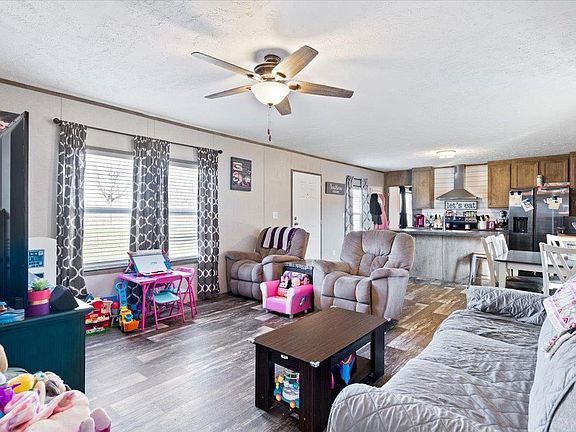 A living room filled with furniture and a ceiling fan.