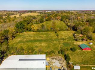 An aerial view of a farm with a red barn in the middle of a field.