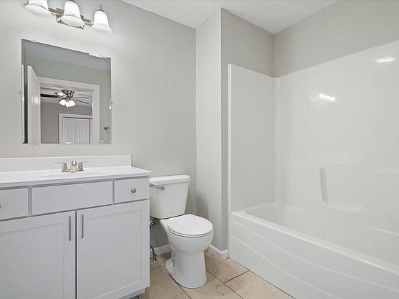 A bathroom with a toilet , sink , and bathtub.