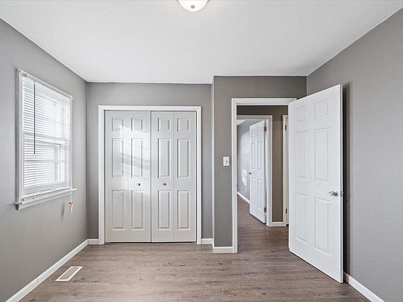 An empty bedroom with gray walls and white doors.